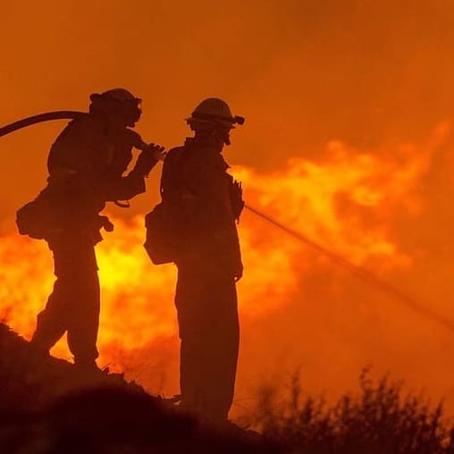 Silhouette of two firefighers